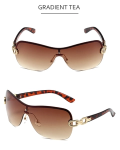 Detail of gradient tea rimless Y2K sunglasses with gold chain temples and tortoiseshell tips