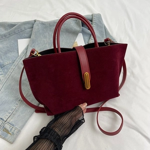 Top view of burgundy frosted suede handbag featuring gold magnetic buckle and leather straps