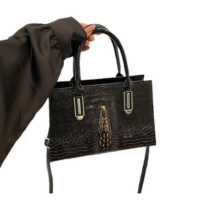 Strukturierte schwarze Handtasche in Kroko-Optik mit goldenen Beschlägen und Tragegriffen
