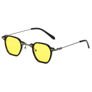 Lunettes de soleil polygonales rétro avec verres jaunes et branches en métal sur fond blanc