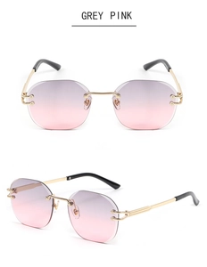 Detail of rimless octagonal sunglasses with grey pink gradient lenses and gold temples