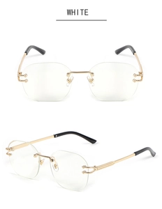 Detail of C-shaped gold metal hinge and sleek rimless lenses on luxury snake-style sunglasses