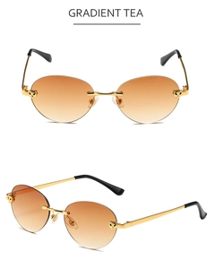 Close-up of frameless gradient tea sunglasses with golden leopard head metal detail