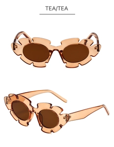Détail de lunettes de soleil couleur thé en forme de pétale avec monture ondulée