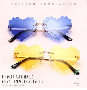 Detail of scalloped heart-shaped sunglasses with metal bridge and blue light protection