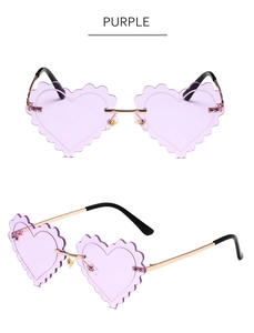 Close-up of purple heart-shaped rimless sunglasses with wavy edges and gold metal frame