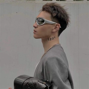 Close-up of silver Y2K steampunk sunglasses and chunky chain necklace on model