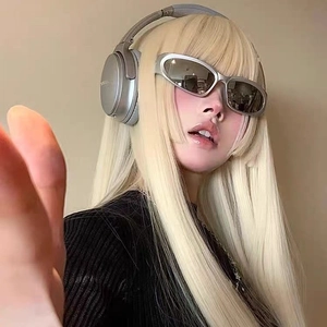 Silver Y2K futuristic oval sunglasses with grey lenses worn with stylish silver headphones