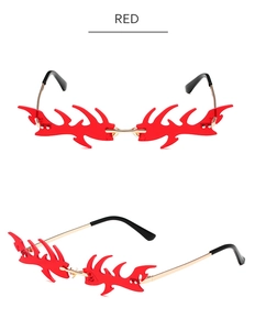 Détail de lunettes de soleil sans monture en forme de flamme rouge avec branches dorées