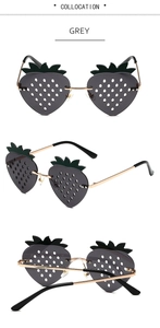Detailed views of strawberry-shaped sunglasses with grey lenses and green leaf accents