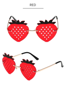 Close-up of funny strawberry shaped sunglasses in red with golden metal temples