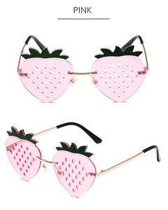 Detailed view of pink strawberry sunglasses with gold metal frames and green leaf decor