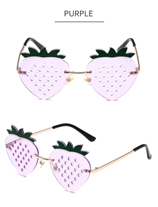 Detail of purple strawberry shaped sunglasses with green leaf accents and metal frames