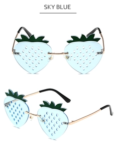 Macro detail of sky blue strawberry shaped sunglasses with green leaves and gold metal frames