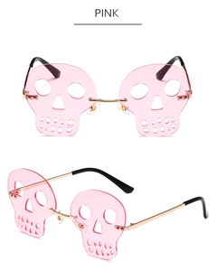 Detail view of pink rimless skull shaped sunglasses with premium gold metal temples