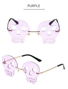 Detail view of purple skull-shaped rimless sunglasses with gold metal bridge and temples