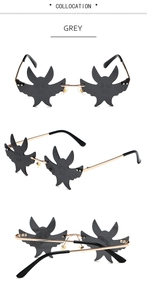 Detailed views of grey rimless bat-shaped sunglasses with gold temples and nose pads