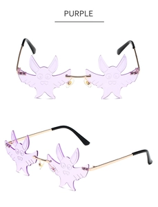 Detail view of purple bat-shaped rimless sunglasses with gold metal frame and clear nose pads