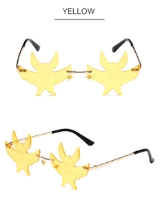 Detail of yellow bat-shaped rimless sunglasses with engraved cartoon facial expressions
