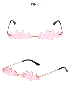 Detailed view of pink bat-shaped rimless sunglasses with gold metal temples and bridge