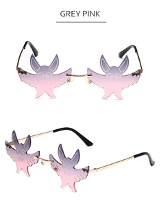 Detail view of rimless bat-shaped sunglasses with grey pink gradient lenses and gold frame