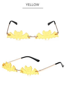 Detail view of yellow bat-shaped rimless sunglasses with elegant gold metal frames