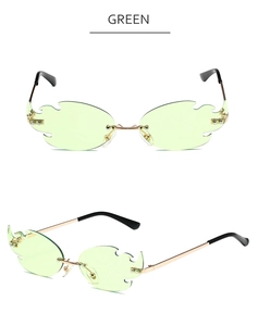 Detailed view of green flame-shaped rimless sunglasses with gold metal bridge