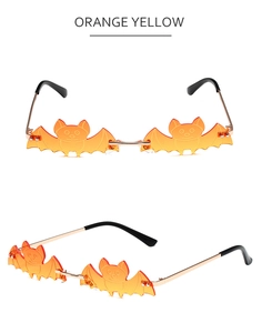 Close-up of bat-shaped orange yellow frameless party sunglasses with gold metal frame