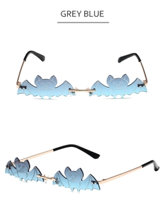 Detail view of grey blue bat shaped rimless sunglasses with gold metal temples
