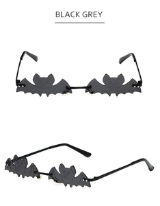 Detail view of stylish bat-shaped sunglasses with black grey lenses for festive parties