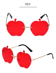 Détail de lunettes de soleil rouges sans monture en forme de pomme avec branches dorées