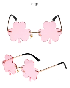 Dettaglio degli occhiali da sole a quadrifoglio rosa senza montatura con ponte dorato