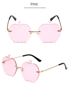 Vue détaillée de lunettes de soleil sans monture en forme de pomme rose et branches dorées