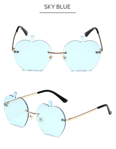 Détail de lunettes de soleil sans monture en forme de pomme bleu ciel et métal doré