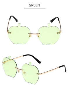 Détail de lunettes de soleil sans monture en forme de pomme avec verres verts et or