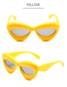 Vues de face et de profil à 45 degrés de lunettes de soleil œil de chat jaunes à monture épaisse