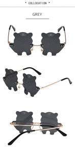 Detail of grey tiger-shaped cartoon sunglasses featuring slim golden metal temples
