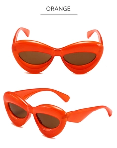 Vue détaillée de lunettes de soleil orange œil-de-chat avec monture en forme de cœur