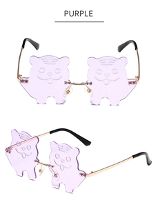 Detail of purple tiger-shaped rimless sunglasses with gold metal frame and engraved lenses