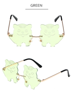 Detail of green tiger-shaped cat-eye sunglasses with gold metal frame and clear lenses