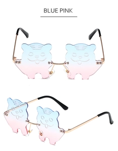 Detail of tiger-shaped blue-pink gradient lenses with golden metal frame sunglasses