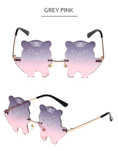 Detail of tiger-shaped novelty sunglasses with purple-pink gradient lenses and gold frame