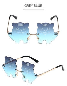 Detail of tiger shaped cartoon sunglasses with gradient blue lenses and golden metal frame