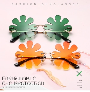 Detailed view of flower shaped rimless sunglasses with gold metal frame and gradient lenses
