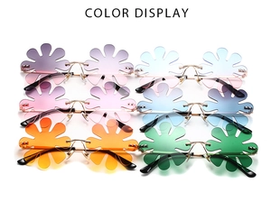 Flat lay of flower shaped rimless sunglasses in six vibrant gradient color displays