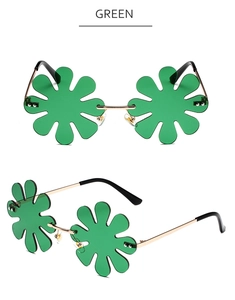 Detailed view of green flower-shaped rimless sunglasses with gold metal bridge and dark temples