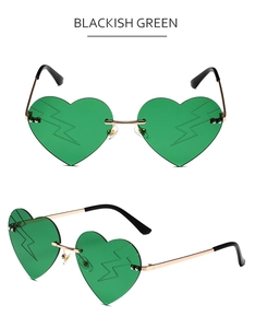 Detail of heart-shaped dark green sunglasses with lightning pattern and gold metal frame