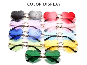 Multiple colorful rimless heart-shaped sunglasses with lightning patterns and gold metal legs