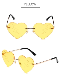 Detail of yellow heart-shaped rimless sunglasses with gold lightning bolt lens patterns