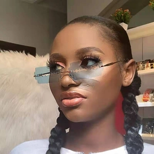 Close-up of model wearing light blue frameless razor blade shaped metal sunglasses